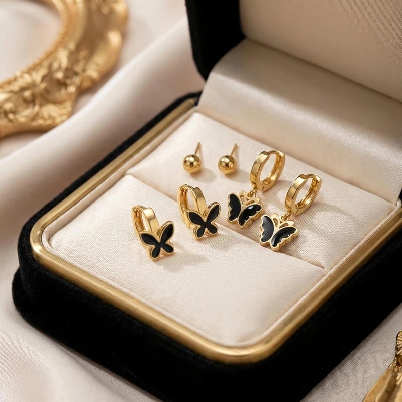 A set of 3 pairs of distinctive gold earrings: gold ball screw, black butterfly-adorned hoops, and a larger, luxurious butterfly pendant. Made of rust-resistant stainless steel for a brilliant shine. - Image 5